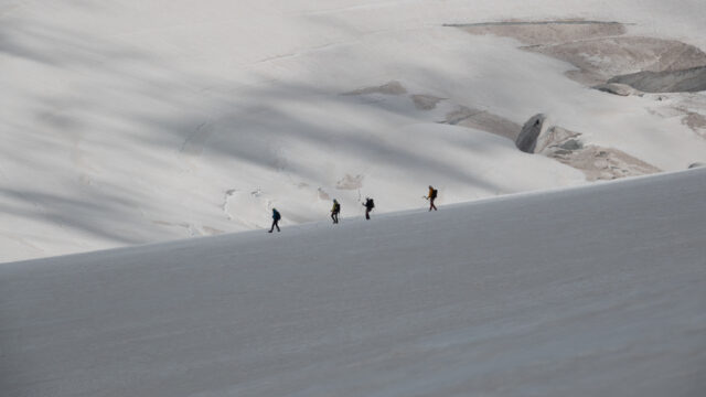 A traveler looks out toward a traditional Himalayan monastery fortress framed by forested mountains, reflecting on the journey and shared adventure