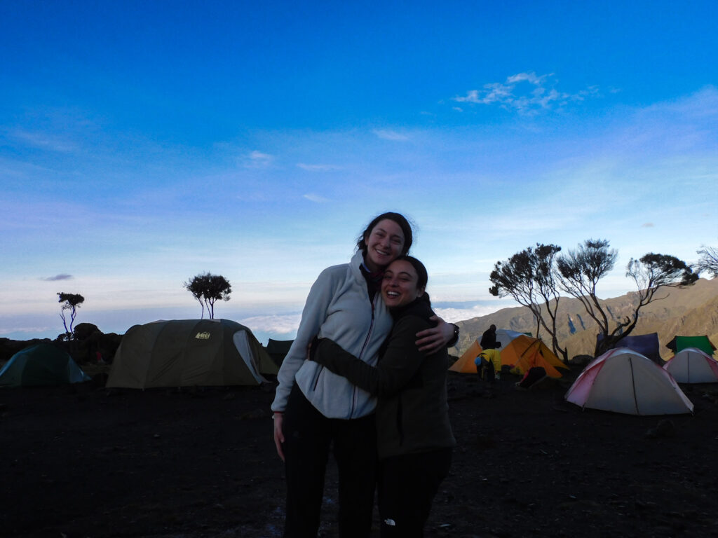 Two trekkers at camp on Mount Kilimanjaro during a Life Happens Outdoors summit adventure