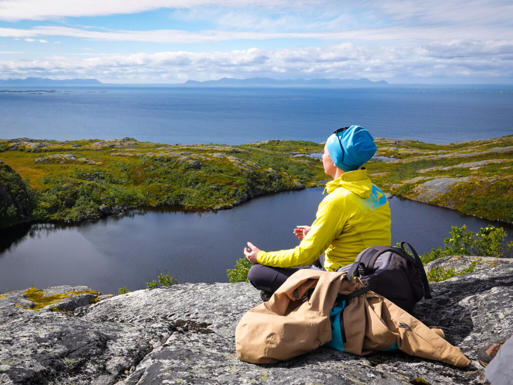 Traveler practicing mindfulness beside a mountain lake before an outdoor adventure