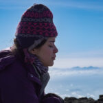 Traveler practicing calm breathing on a snowy mountain during a big adventure