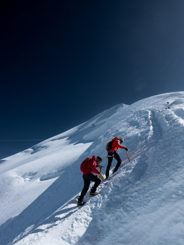 Climbers ascending a steep snowy ridge during a guided alpine climb