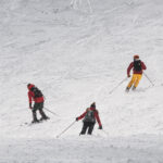 Group skiing down a snowy mountain during a winter adventure travel experience