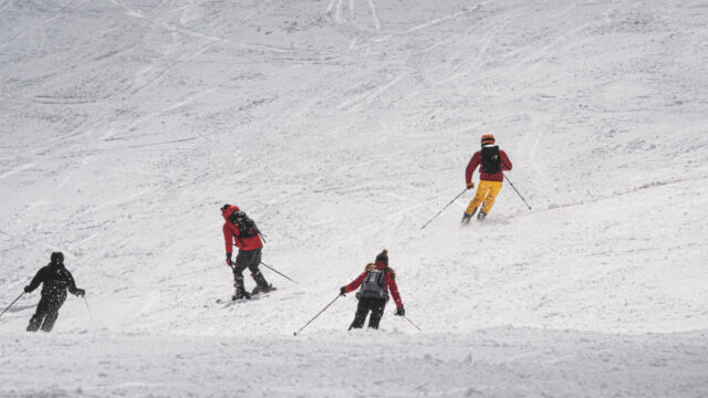 Group skiing down a snowy mountain during a winter adventure travel experience