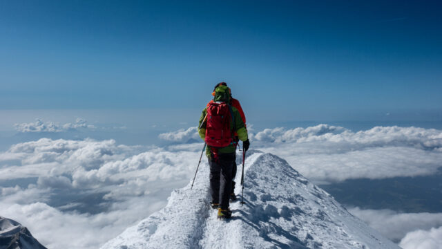 Climber walking along the Bosses Ridge on the Mont Blanc climb via the Goûter Route