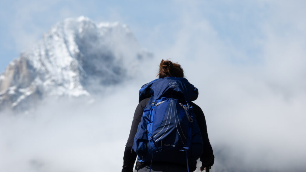 Trekker at altitude on the Grand Col Ferret crossing in changing alpine conditions on the Tour du Mont Blanc