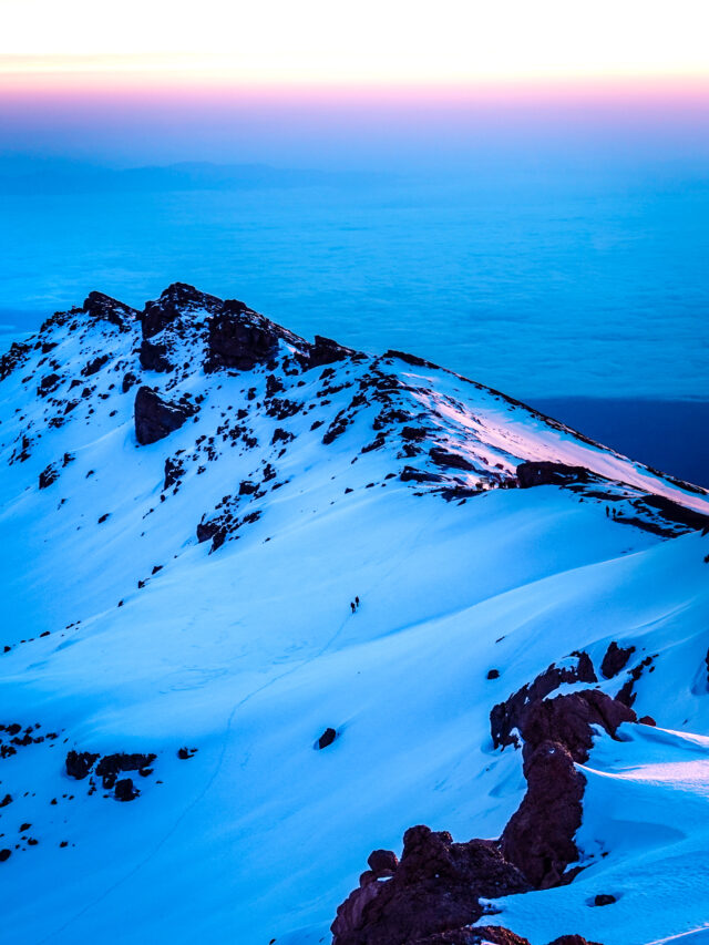 Dawn light over the snowy upper slopes of Mount Kilimanjaro.