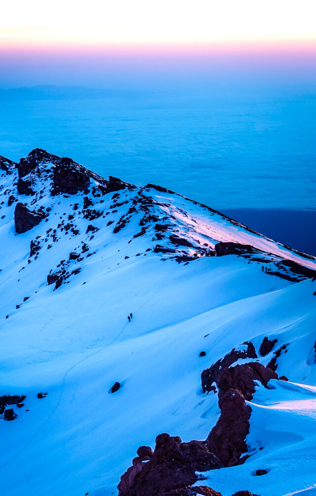 Dawn light over the snowy upper slopes of Mount Kilimanjaro.