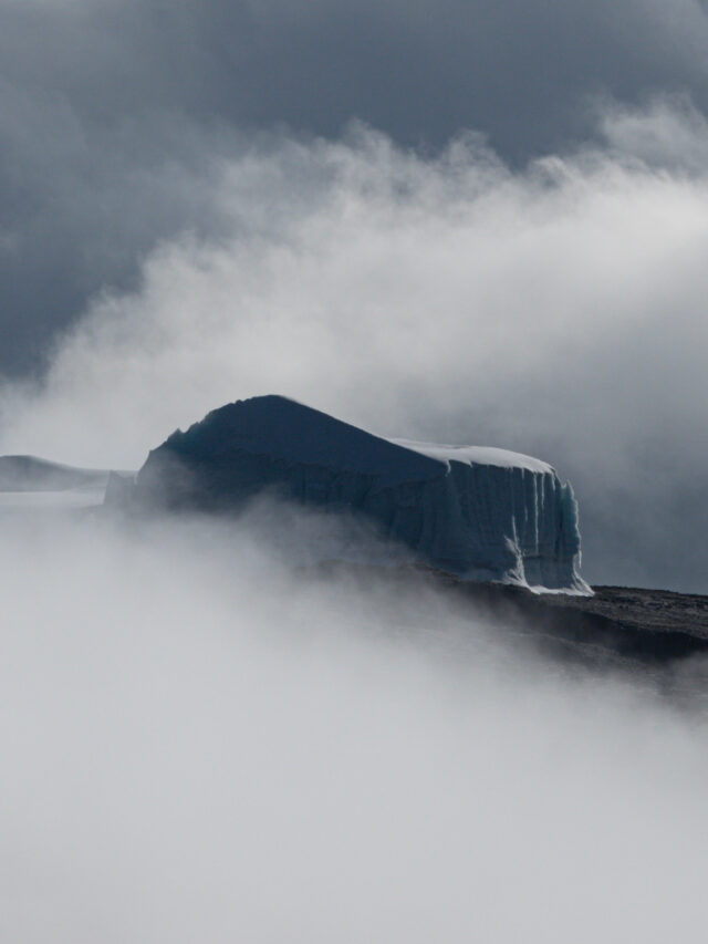 Ice covered formations high on Mount Kilimanjaro emerging through cloud.