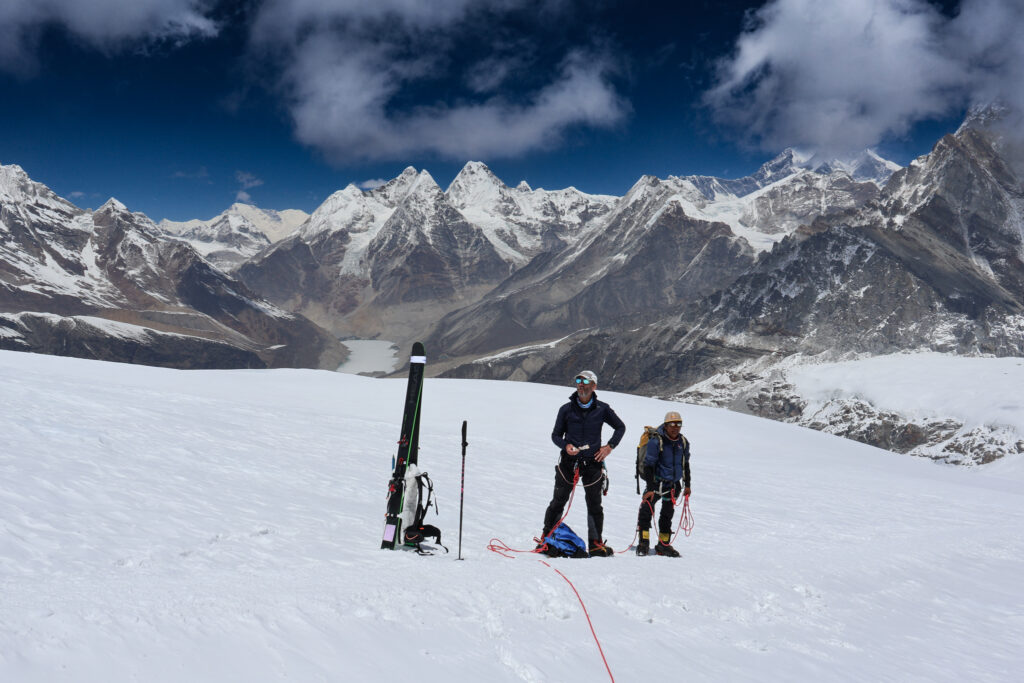 Climbers preparing for ski touring on Mera Peak glacier surrounded by high altitude Himalayan landscape