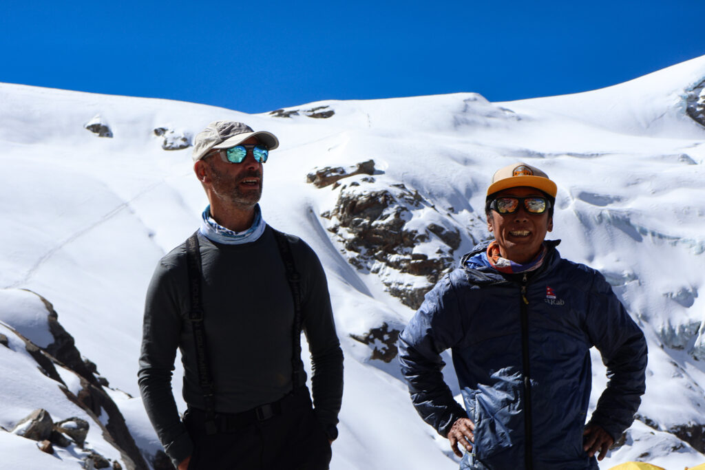 Ski touring team standing on Mera Peak glacier preparing for ascent in high altitude Himalayan conditions