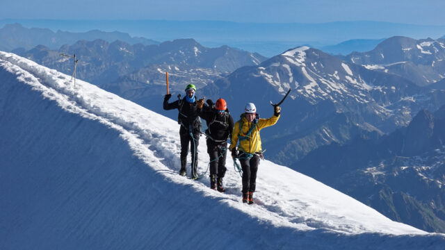 Three climbers on the exposed upper ridge of Mont Blanc during a guided ascent.