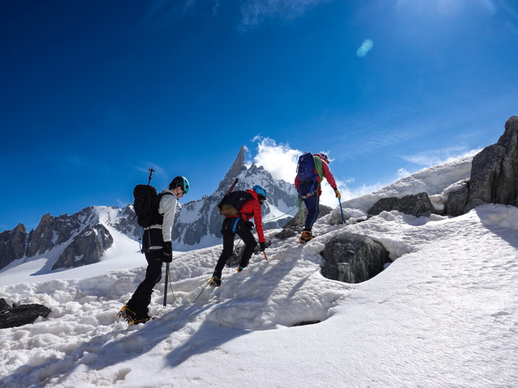 Climbers training with a guide on mixed snow and rocky terrain in the Mont Blanc massif