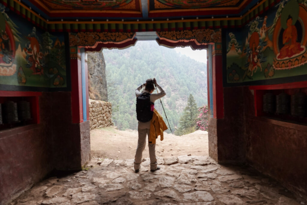 Trekker standing inside a painted monastery doorway on the Everest Base Camp trail in Nepal