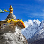 Buddhist stupa and snow covered Himalayan peaks on the Everest Base Camp trekking route in Nepal