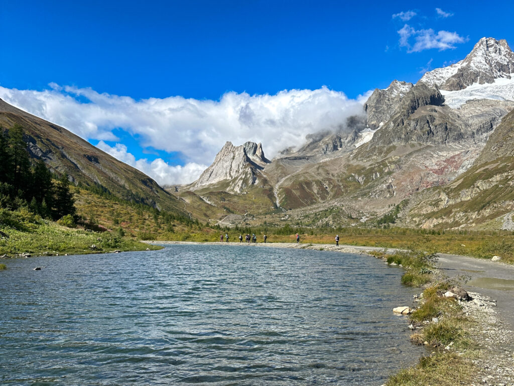 Tour du Mont Blanc trail beside an Alpine lake with Mont Blanc mountain views