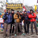 Trekkers moving slowly on Kilimanjaro with the mountain summit behind them