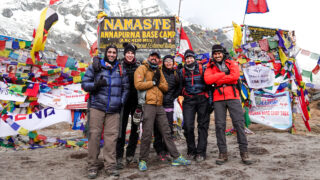 Trekkers moving slowly on Kilimanjaro with the mountain summit behind them
