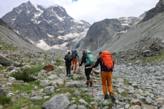Trekkers crossing rocky alpine terrain on a challenging Chamonix to Zermatt style trek in the Alps