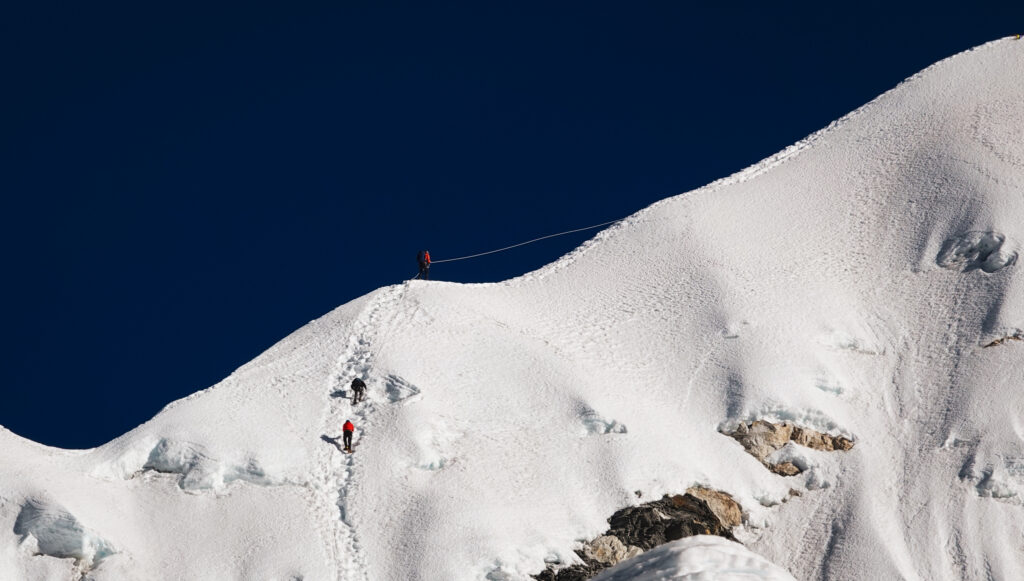 Climbers ascending the fixed rope headwall on Island Peak during a Life Happens Outdoors expedition in Nepal