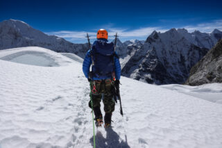 Life Happens Outdoors climber on Island Peak with snow covered Himalayan mountains across the Everest region