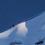 Climbers moving across the glacier route on Island Peak with fixed ropes during a Life Happens Outdoors climb in Nepal