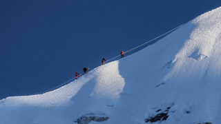 Climbers moving across the glacier route on Island Peak with fixed ropes during a Life Happens Outdoors climb in Nepal