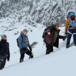 Market Securities participants moving through snowy alpine terrain with a guide during a Life Happens Outdoors Chamonix team building experience.
