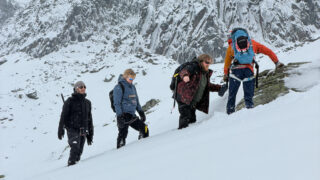 Market Securities participants moving through snowy alpine terrain with a guide during a Life Happens Outdoors Chamonix team building experience.