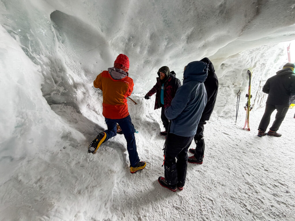 Market Securities team members exploring an ice cave during a Life Happens Outdoors corporate alpine experience in Chamonix.