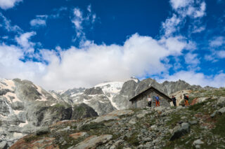 Trekkers outside an alpine hut on a guided Walker’s Haute Route style journey from Chamonix to Zermatt with Life Happens Outdoors