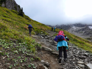 Trekkers climbing a steep rocky alpine trail showing the difficulty of the Walker’s Haute Route
