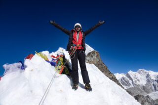 Climber standing on a Himalayan summit during a Lobuche East climbing expedition in Nepal