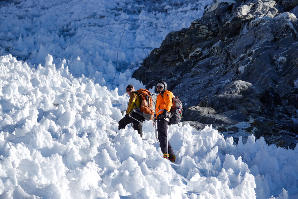 Climbers moving through steep snow and rock on fixed ropes during a Lobuche Peak climbing expedition in Nepal