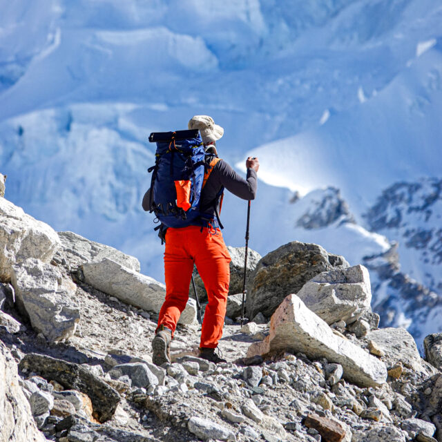 Trekker carrying expedition gear across rocky terrain on the approach to Island Peak in Nepal