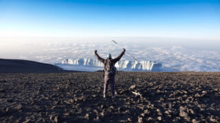Fred Sfeir standing above Kilimanjaro’s glaciers during the Moving Mountains adventure documentary.