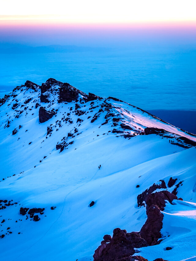 Portrait view of a snow-covered Kilimanjaro ridge above the clouds from the Moving Mountains documentary project.