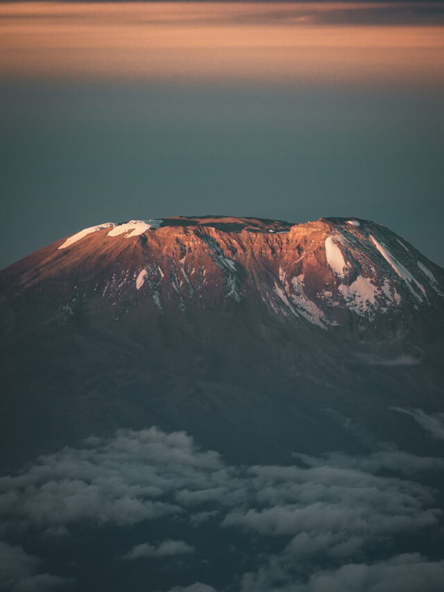 Portrait view of Mount Kilimanjaro at sunrise above the clouds for the Moving Mountains documentary page.