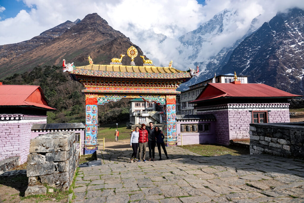 Life Happens Outdoors trekkers beneath the decorated entrance to Tengboche Monastery in Nepal’s Everest region