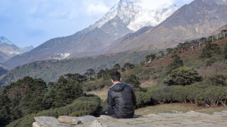 A trekker resting and looking across the Himalayan landscape during a trek through Nepal’s Everest region