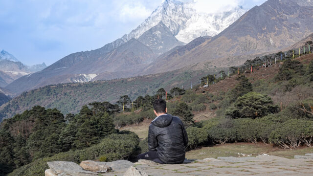 A trekker resting and looking across the Himalayan landscape during a trek through Nepal’s Everest region