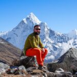 Life Happens Outdoors trekker resting at high altitude with Ama Dablam behind him in Nepal
