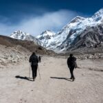 Trekkers walking through the Khumbu towards Everest Base Camp beneath snow covered Himalayan peaks