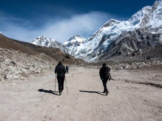 Trekkers walking through the Khumbu towards Everest Base Camp beneath snow covered Himalayan peaks