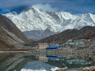 Gokyo village beside Gokyo Lake beneath snow covered Himalayan peaks in Nepal