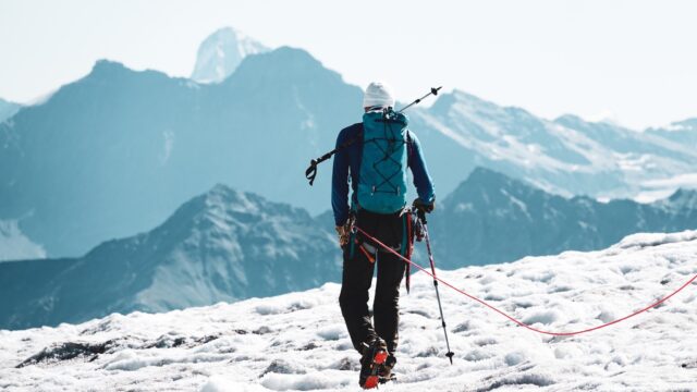 Mountaineer carrying technical equipment on a glacier, representing specialist review of high-altitude and Nepal climbing content.