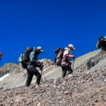 Trekkers ascending a rocky high-altitude slope on Aconcagua during acclimatisation