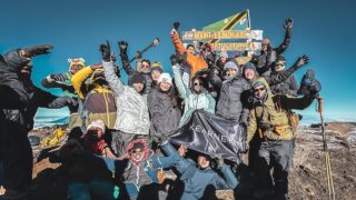 Kearney climbers at Uhuru Peak on Kilimanjaro holding a Kearney flag during an earlier Life Happens Outdoors expedition.